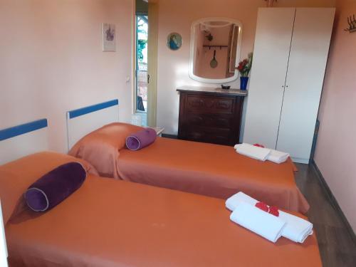 two orange beds in a room with a mirror at Holiday Maison Villa Arci in Giardini Naxos