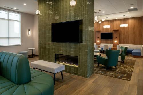 a waiting room with a fireplace and a tv at Residence Inn by Marriott Montgomery Downtown in Montgomery