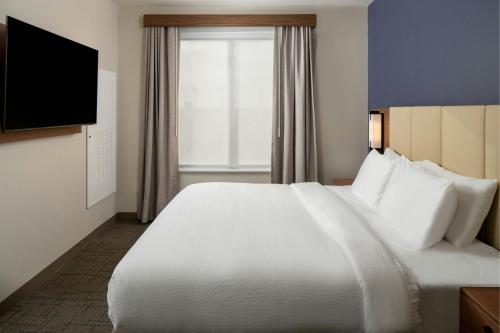 a hotel room with a large white bed and a window at Residence Inn by Marriott Montgomery Downtown in Montgomery