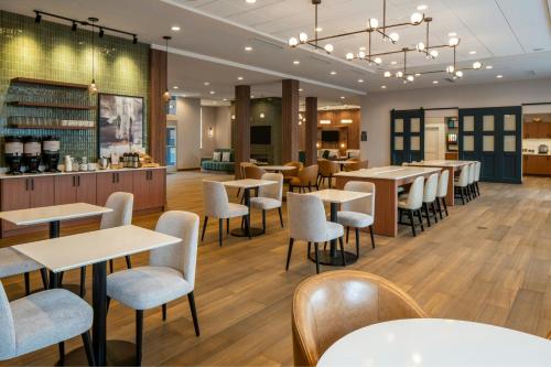 a restaurant with tables and chairs and a bar at Residence Inn by Marriott Montgomery Downtown in Montgomery