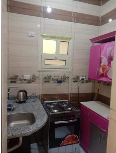 a small kitchen with a stove and a sink at الغردقة - اول ممشى شيرى in Hurghada