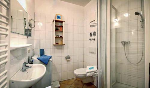 a bathroom with a sink and a toilet and a shower at Ostsee43 - Apartment Ole in Rostock