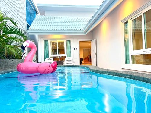 a pink inflatable flamingo in a swimming pool at City house- 171, Private pool villa 4 bed5bath near walking St, BBQ in Pattaya South