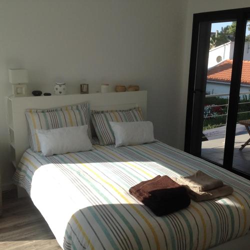 a bedroom with a bed with towels on it at Villa Lisbonne piscine plage in Aroeira