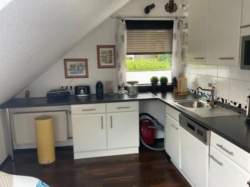 a kitchen with white cabinets and a sink and a window at Emma in Oberhausen