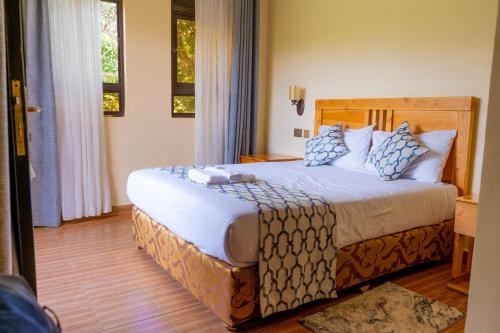 a bedroom with a large bed with blue and white pillows at Nyeri Club in Nyeri