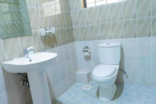 a bathroom with a white toilet and a sink at Nyeri Club in Nyeri