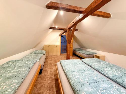 a attic room with two beds and a window at Roprachtická chalupa in Roprachtice