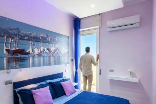 a man looking out the door of a bedroom at A View on Cagliari in Cagliari