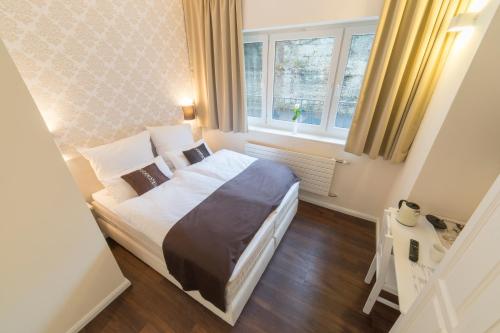 a bedroom with a large bed and two windows at List Five - Your British Guesthouse in Stuttgart