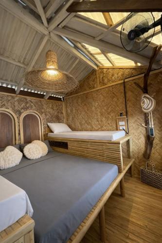 a bedroom with two beds and a ceiling at 74YOU Beach Resort and Restaurant in Puerto Princesa City