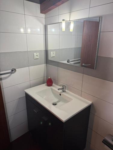 a bathroom with a sink and a mirror at Casa Portela in Marialva