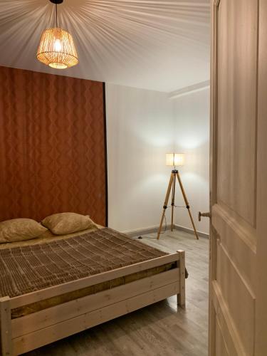 a bedroom with a bed and a lamp and a tripod at Les Cocons de Nabeillou in Graulhet