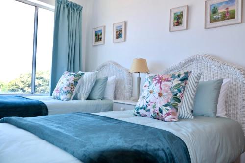 two beds in a room with a window at Apartment Sapphire in Herolds Bay