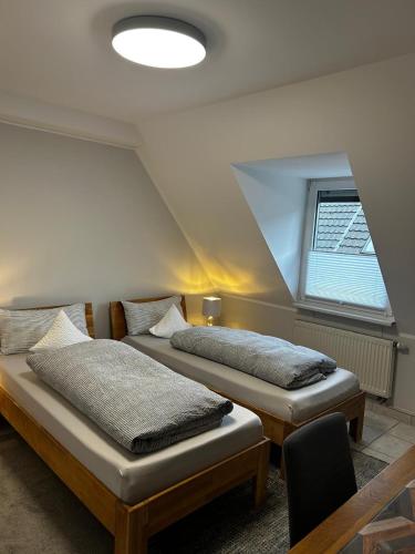 two beds sitting in a room with a window at Hotel zum Schiffchen in Brüggen