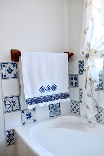 a towel hanging on a wall with blue and white tiles at Apartment Sapphire in Herolds Bay