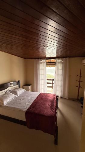 a bedroom with a large bed and a window at Casa de praia da Michelly in Mangaratiba