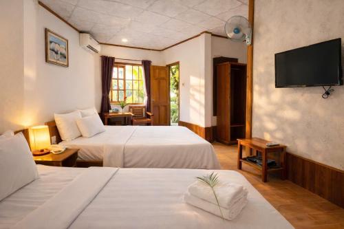 a hotel room with two beds and a flat screen tv at FORTUNE HOTEL 2 LUCKY STAY Phu Quoc in Phú Quốc