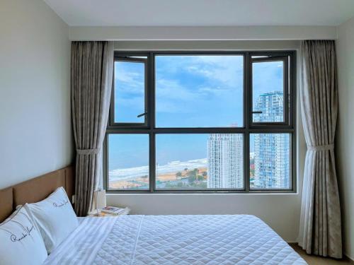 a bedroom with a large window with a large bed at Căn hộ The Sóng Vũng Tàu Infinity Pool - Near Sea Tháp Tam Thắng in Vung Tau