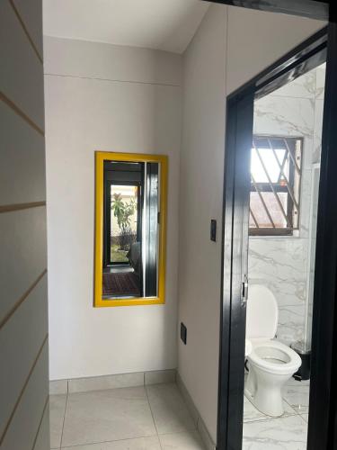 a bathroom with a mirror and a toilet at Ekuku Snug in Oshakati