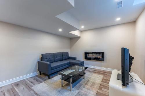 a living room with a blue couch and a tv at Spacious 7BR Home with Private Yard & Fast WiFi! in Brampton