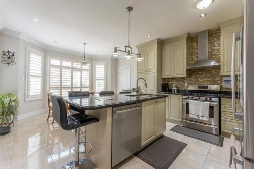 a kitchen with a large island in the middle at Spacious 7BR Home with Private Yard & Fast WiFi! in Brampton