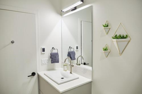 a white bathroom with a sink and a mirror at Ripper Retreat in Revelstoke