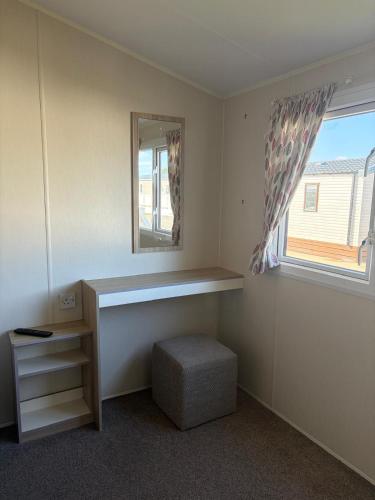 a room with a desk and a mirror and a window at PG173 Golden Palm Resort 6 Berth Caravan With Decking in Chapel Saint Leonards