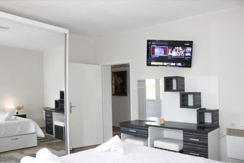 a bedroom with a desk and a tv on the wall at Corner Five in Negotino
