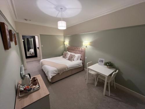 a small room with a bed and a table at The Doonleigh suite in Ayr