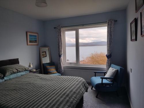 a bedroom with a bed and a window with a view at Tobar nan Iasgair Lismore in Achnacroish