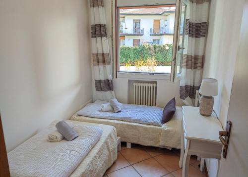 two beds in a small room with a window at Last Minute Booking in Peschiera del Garda