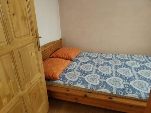 a bedroom with a bed with a blue and white quilt at Nelly Apartman in Gheorgheni