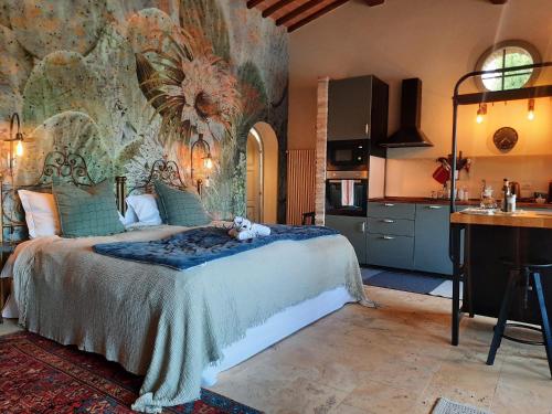 a bedroom with a large bed and a kitchen at Gli sterpi in Sinalunga