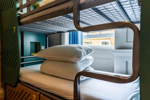 a bunk bed with pillows on it in a room at Bath Backpackers in Bath