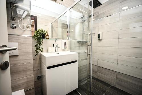 een badkamer met een witte wastafel en een douche bij Laurea Rooms in Split