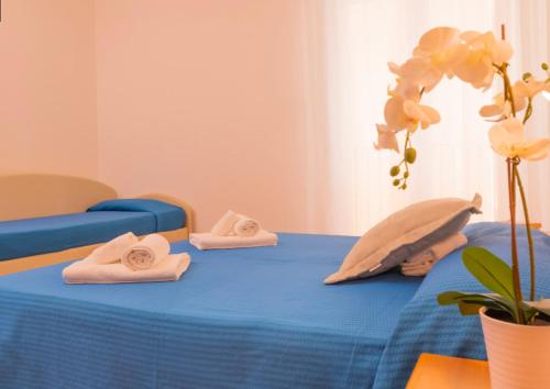a room with a bed with towels on it at Hotel Merano in Misano Adriatico
