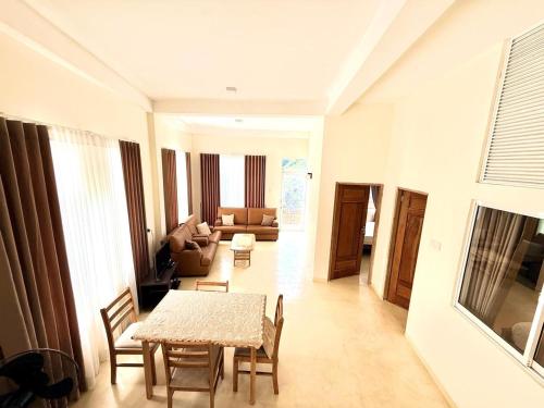 a living room with a table and chairs and a couch at Misty Hues in Kandy