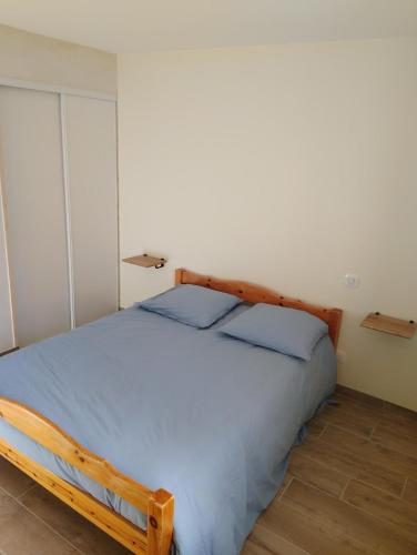 a bedroom with a wooden bed in a room at Ty Véron, labellisé PMR in Asnières-la-Giraud