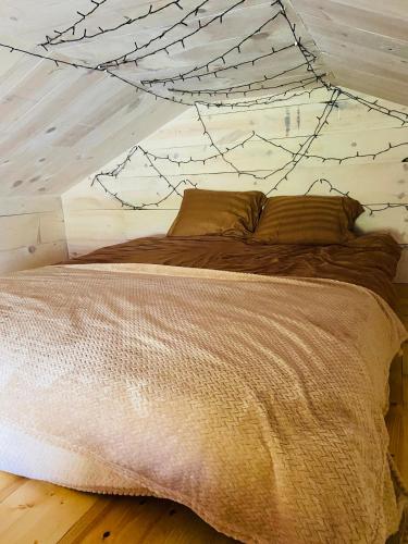 a bed in a bedroom with a spiderwebhered ceiling at Väikse haldja onn in Majala