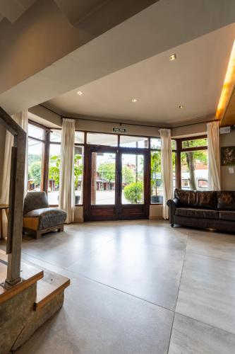 an open living room with a couch and windows at Tunqueley Hotel in San Martín de los Andes