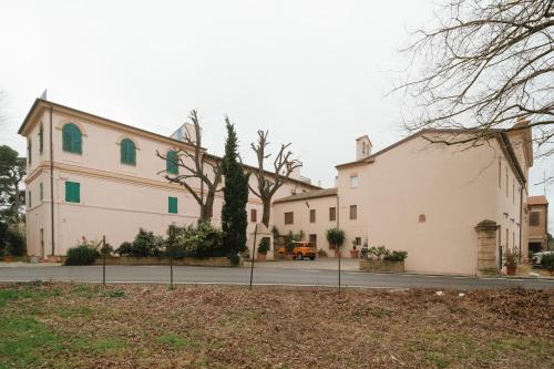 a large white building with green windows at Il Conventino 46 in Falconara Marittima