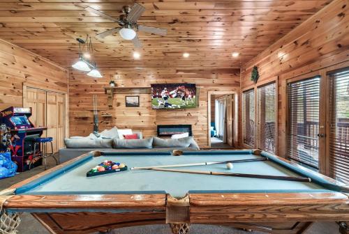 a pool table in a room with wooden walls at Private Sauna Cabin Sleeps 34 Game Rooms in Pigeon Forge