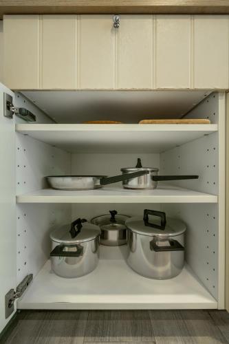 a kitchen with white cabinets and pots and pans at Cozy Studio Apartment E414 in Phuket