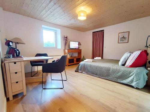 a bedroom with a bed and a desk and a deskablish at La tournette - Sur la route d'Annecy in Alby