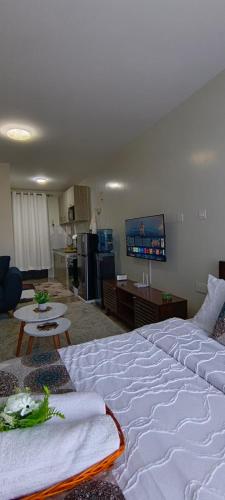 a large white bed in a room with a kitchen at BlueByMis Studio Apartment in Muchatha