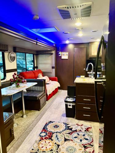 an rv with a kitchen and a living room at Jennys creekside bliss in Otto