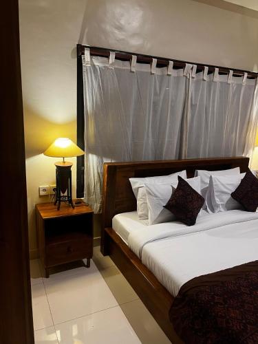 a bedroom with two beds and a table with a lamp at Batan Bingin House in Ubud