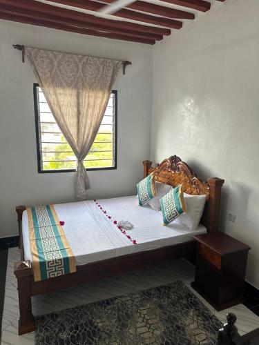 a bedroom with a large bed with a window at Munaa House Wiyoni in Lamu