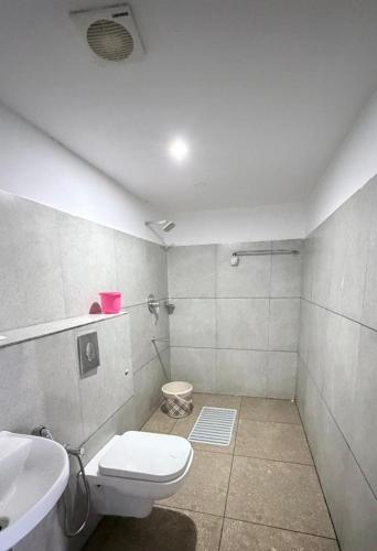 a bathroom with a toilet and a sink at Stillora Hotel And Resorts in Sultan Bathery